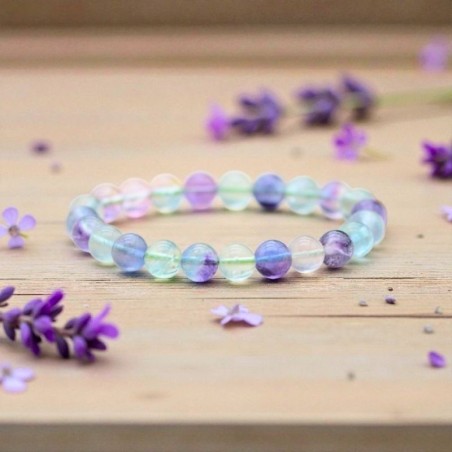Bracelet en Fluorine multicolore présenté sur un fond en bois clair, révélant les couleurs naturelles de chaque perle