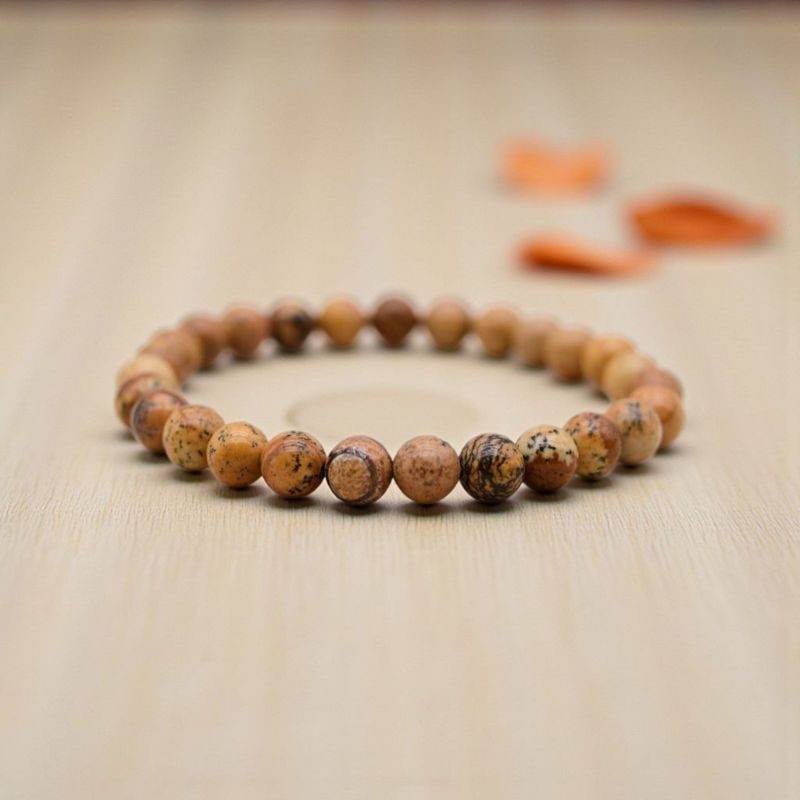 Bracelet en Jaspe paysage, présenté sur un fond en bois clair, révélant les motifs évoquant des paysages désertiques