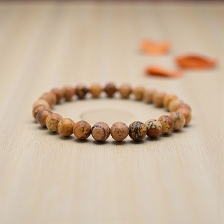 Bracelet en Jaspe paysage, présenté sur un fond en bois clair, révélant les motifs évoquant des paysages désertiques