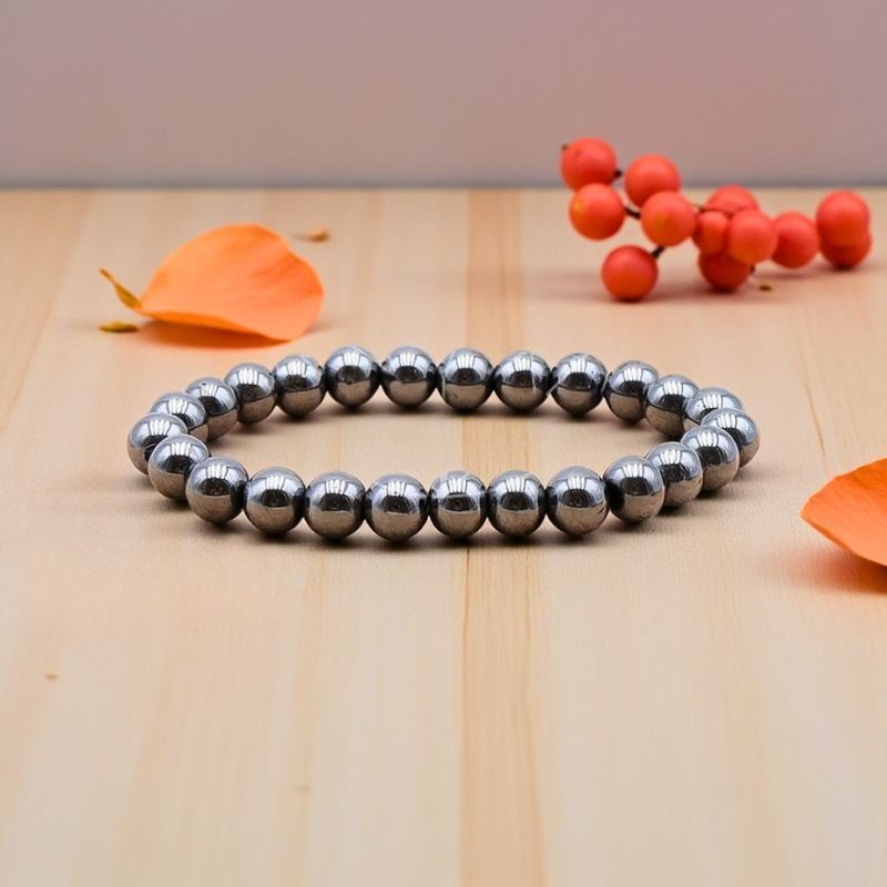 Bracelet en Hématite naturelle de 8 mm présenté sur un fond en bois clair, révélant son élégance sobre et intemporelle