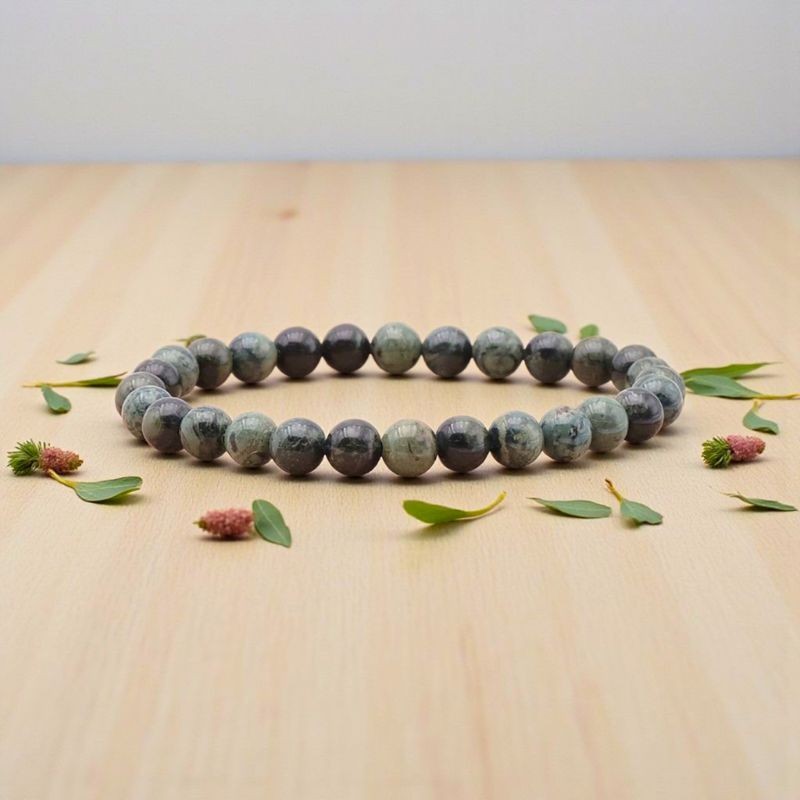Bracelet en Jaspe Kambaba présenté sur un fond en bois clair, révélant les motifs uniques de chaque pierre
