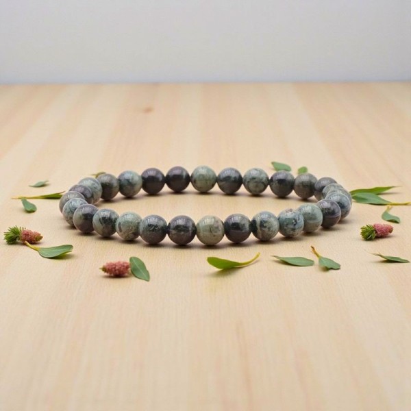 Bracelet en Jaspe Kambaba présenté sur un fond en bois clair, révélant les motifs uniques de chaque pierre