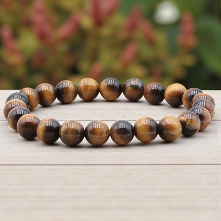 Bracelet en Œil de tigre naturel de 8 mm porté au poignet, mettant en valeur les reflets dorés et bruns de cette pierre