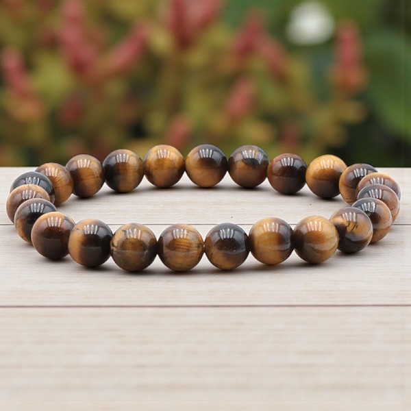 Bracelet en Œil de tigre naturel de 8 mm porté au poignet, mettant en valeur les reflets dorés et bruns de cette pierre