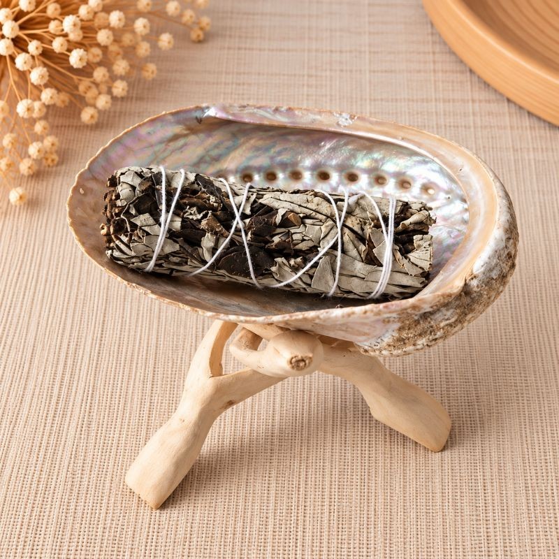 Smudge de sauge blanche et Yerba Santa dans une coquille d'ormeau