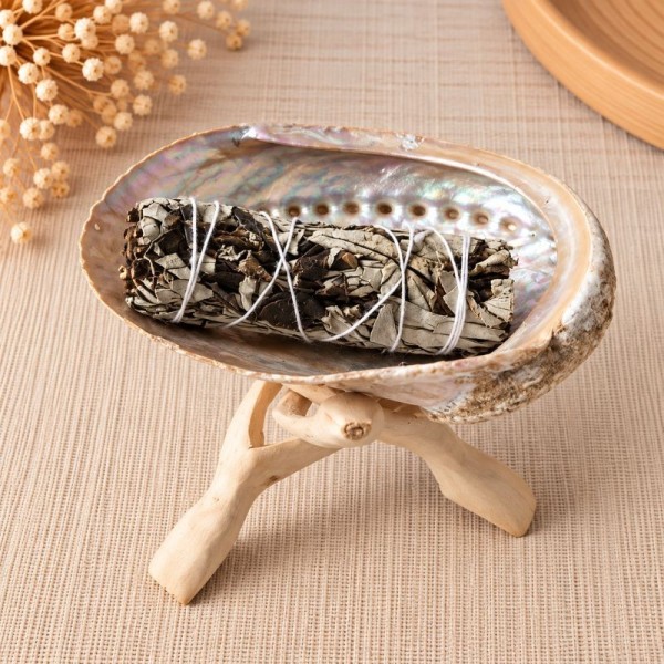 Smudge de sauge blanche et Yerba Santa dans une coquille d'ormeau