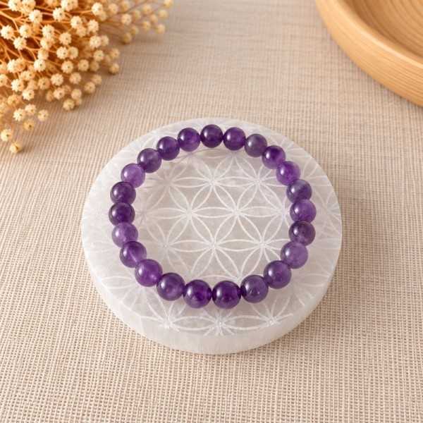 Bracelet en pierres naturelles posé sur une plaque de rechargement en sélénite Fleur de Vie
