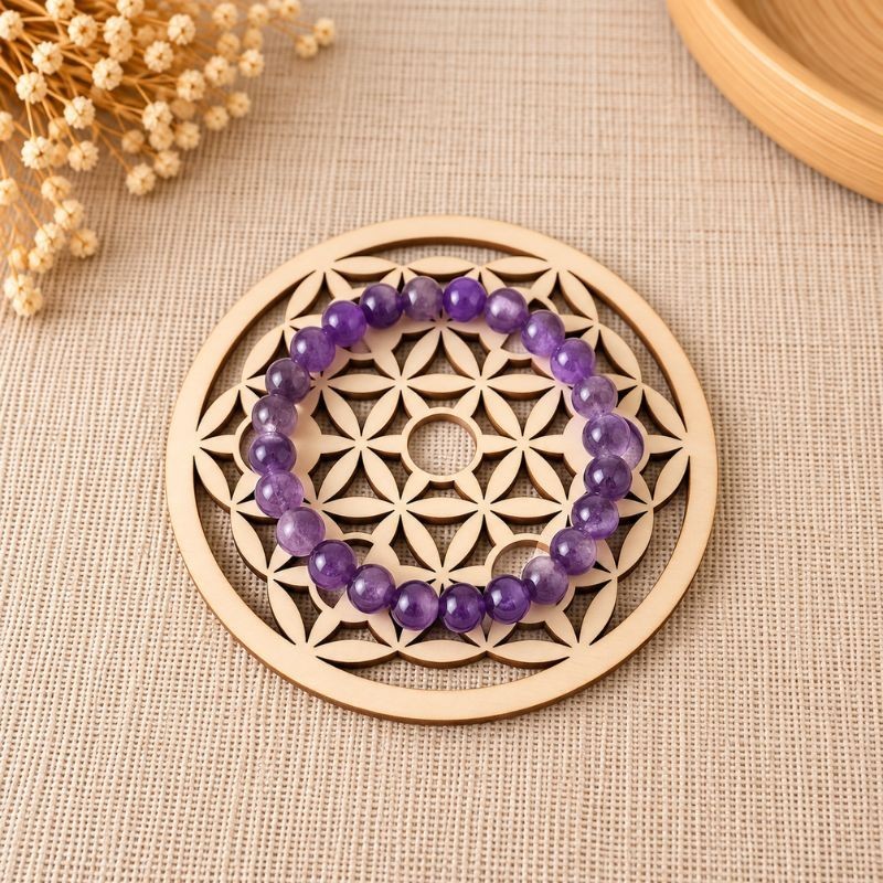 Bracelet en pierres naturelles posé sur une plaque en bois Fleur de Vie